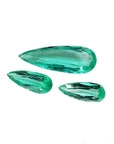 Three loose, pear-shaped Colombian emeralds with sparkling medium light green color.