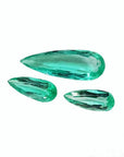 Three loose, pear-shaped Colombian emeralds with sparkling medium light green color.