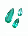 Three pear-shaped, medium light green Colombian emeralds, eye-clean and sparkling.
