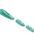 Three sparkling pear-shaped Colombian emeralds, one large and two smaller, on a white background.