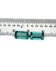 Emerald-cut matching pair loose emeralds from Muzo Colombia, front side tables and crowns visible with a ruler sizer