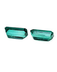 Matching pair of emerald-cut 3.38 ct. loose emeralds with vibrant bluish-green color.