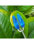 Blue opal earrings on a green leaf background.