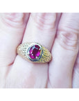 Men's 18K yellow gold ring with a sparkling pinkish-red oval cut Burma ruby, prong-set.