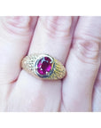 Men's 18K yellow gold ring with a sparkling pinkish-red oval cut Burma ruby, prong-set.