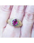Men's 18K yellow gold ring with a sparkling pinkish-red oval cut Burma ruby, prong-set.
