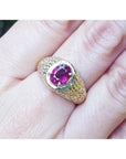 Men's natural oval ruby ring unisex-solitaire yellow gold, front top view on a person's finger