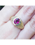 Men's 18K yellow gold ring with a sparkling oval-cut pinkish-red Burma ruby solitaire.