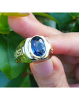 Men's genuine blue sapphire solitaire ring oval cut, with a medium-dark blue hue, that highlights its brilliance and clarity.