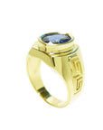 Men's 18K yellow gold ring with an oval-cut blue sapphire and Greek key design.