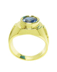 Men's 18K yellow gold ring with a bezel-set oval blue sapphire and Greek key band design.