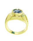 Men's 18K yellow gold ring with a bezel-set oval blue sapphire and Greek key band design.