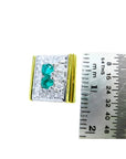 14K yellow gold men's cufflinks with two emeralds surrounded by diamonds, next to a ruler.