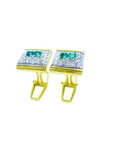 Pair of cufflinks with emeralds and diamonds on a white background