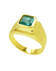 A yellow gold emerald pinky ring for man displaying its top bezel set and partial sides perspective.