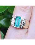 This men’s ring features a bezel-set emerald, accented with natural diamonds, and crafted from 14k yellow gold.