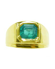 A Men's emerald solitaire ring bezel set 14k yellow gold displaying the topside view.