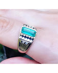 Men's 14K yellow gold ring with a rectangular Colombian emerald and burnish-set diamonds.