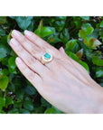 Men's 14K yellow gold horseshoe ring with a cushion-cut emerald and burnish-set diamonds.