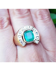 A 14k gold men’s emerald ring featuring a horseshoe design with accent diamonds, worn on the hand.