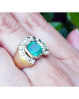 Men's 14K yellow gold horseshoe ring with a cushion-cut emerald and burnish-set diamonds.