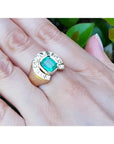Men's 14K yellow gold horseshoe ring with a cushion-cut emerald and burnish-set diamonds.