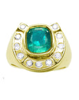 A gold ring for men horseshoe design with a natural colombian emerald and accent diamonds on a topside position.