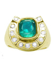 A gold ring for men horseshoe design with a natural colombian emerald and accent diamonds on a topside position.