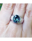 Men's 14K white gold ring with a large oval-cut greenish-blue Australian sapphire and diamond accents.