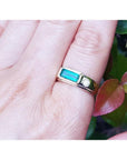 A 14k yellow gold men's emerald ring with accent single diamond on a person's hand.