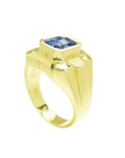 Men's 18K yellow gold solitaire ring with a bezel-set, octagonal vivid blue sapphire.