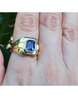 Men's 18K yellow gold solitaire ring with a vivid blue octagonal sapphire, bezel set.