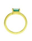 A yellow gold minimalist solitaire emerald ring showing the lateral profile new.