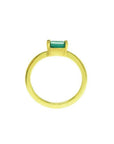 Minimalist 14K yellow gold ring with a horizontal emerald-cut green solitaire.