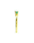 Minimalist 14K yellow gold ring with a prong-set, east-west oriented emerald solitaire.