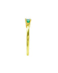 Minimalist 14K yellow gold ring with a prong-set, east-west oriented emerald solitaire.
