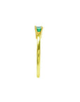 Minimalist 14K yellow gold ring with a prong-set, east-west oriented emerald solitaire.