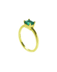 The side profile perspective of a minimalist emerald solitaire ring representing May's birthstone jewelry.