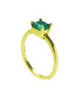 The side profile perspective of a minimalist emerald solitaire ring representing May's birthstone jewelry.