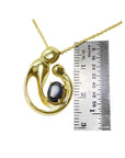 14K yellow gold mother and child pendant with an oval blue sapphire, shown with a ruler.