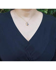 14K yellow gold mother and child sapphire pendant necklace on a woman's chest.