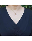 14K yellow gold mother and child sapphire pendant necklace on a woman's chest.