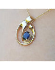 Displaying a gold pendant with a natural blue sapphire on a woman's collar neck