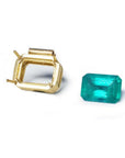 18K yellow gold slider pendant setting next to a vibrant deep green emerald.