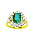 A 14K yellow gold ring featuring a Muzo Colombian emerald surrounded by a halo of diamonds, showcased from a topside perspective.