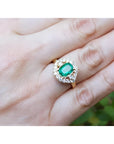 1.43 ct cushion-cut Muzo Colombian emerald ring with marquise diamond halo in 14K yellow gold.