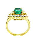 A yellow gold emerald ring displaying its lateral perspective fron the top setting. gallery and band ring.