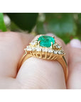 1.43 ct cushion-cut Muzo Colombian emerald ring with marquise diamond halo in 14K yellow gold.