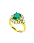 The side of this emerald ring shows the top cushion cut gemstone, the halo diamonds and band in yellow gold.