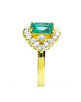 A Muzo colombian emerald ring displaying the top center piece, a halo diamond and the band in yellow gold.